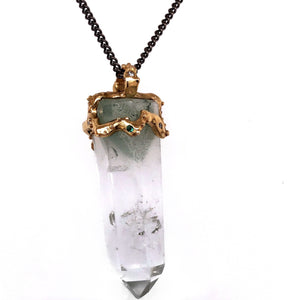 Clear quartz crystal attached to necklace by handmade gold "crown" on top  that also features inset gems