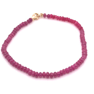 String of handmade looking purple-pink ruby beads with gold clasps