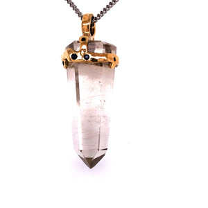 Clear quartz crystal attached to necklace by gold casing 